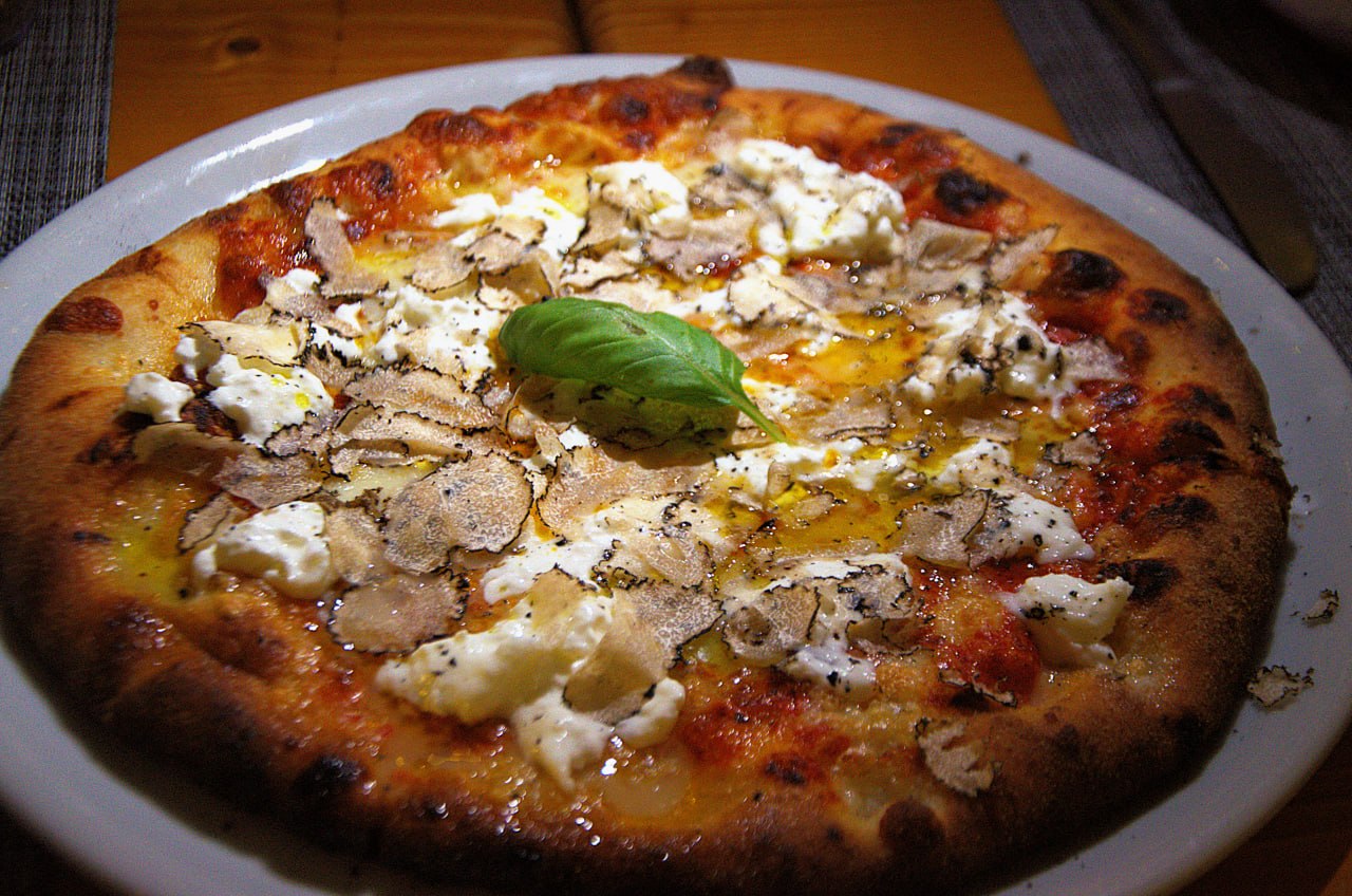 Pizza con formaggio, basilico e scaglie di tartufo